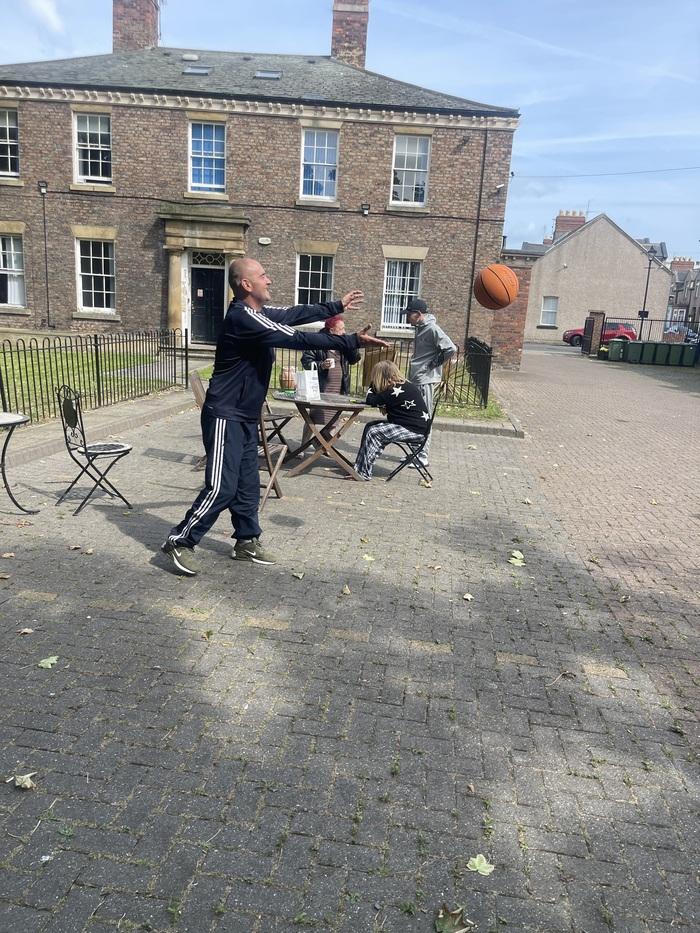 Residents playing ball games in the sunny West Lodge courtyard